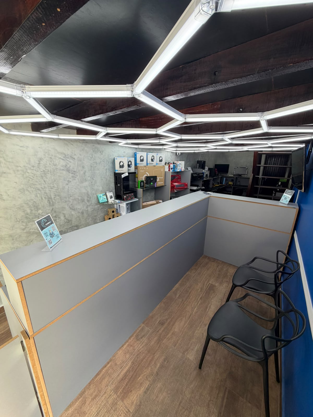 Interior da loja Sampaio TechLAB com balcão de atendimento, iluminação em LED e prateleiras de produtos